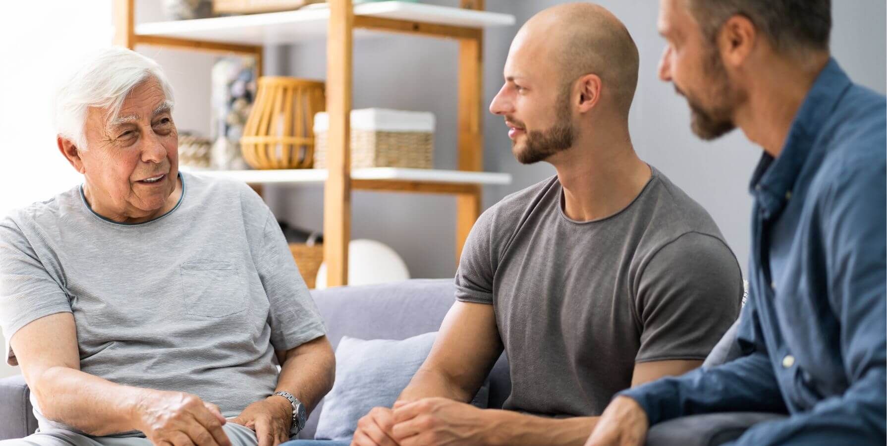 A grandfather talks with his son and grandson during a mental health intervention