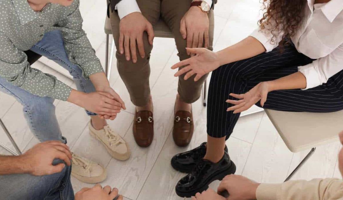 A supportive group therapy session where individuals openly share their thoughts, sparking the consideration: Do I need rehab?