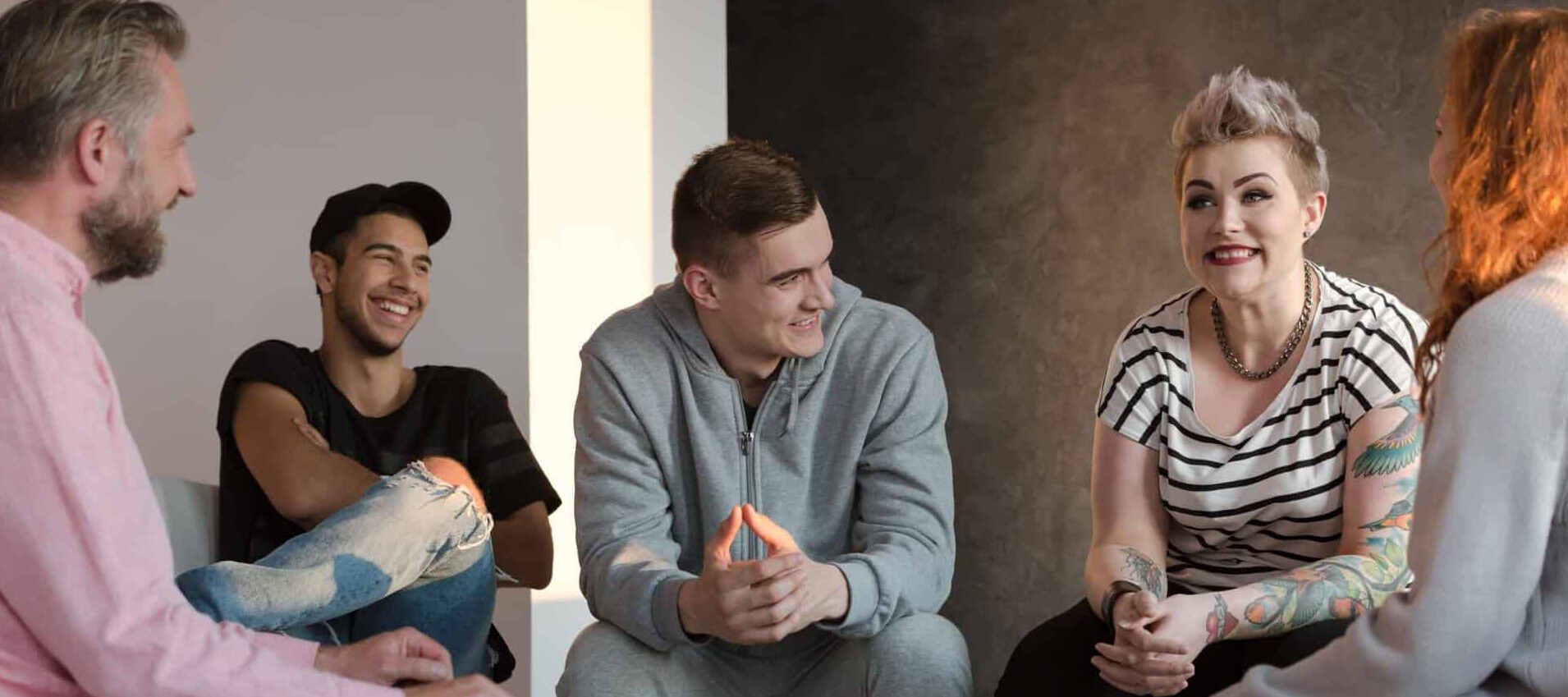 A group therapy session where people share and support one another in a positive, open environment focused on addiction recovery.