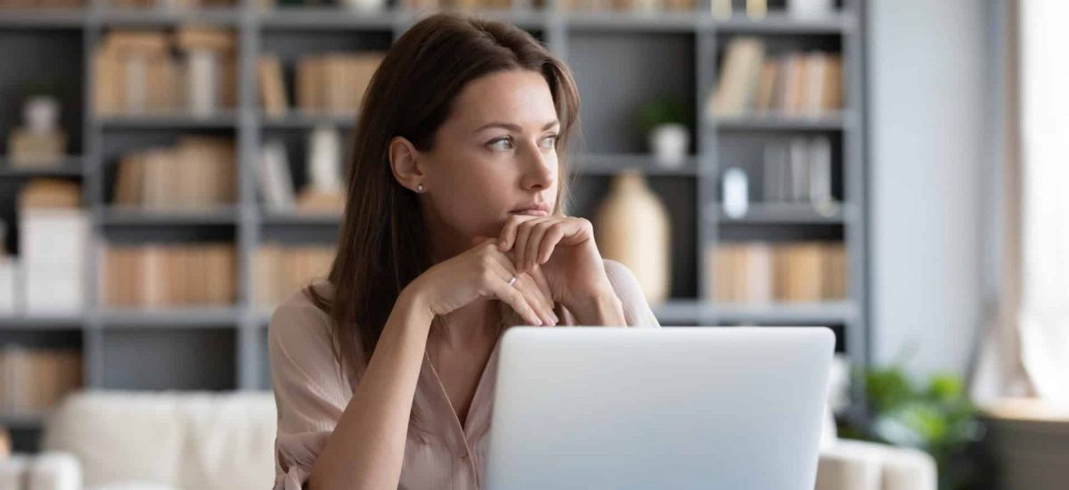 women at a computer logging into virtual rehab for addiction