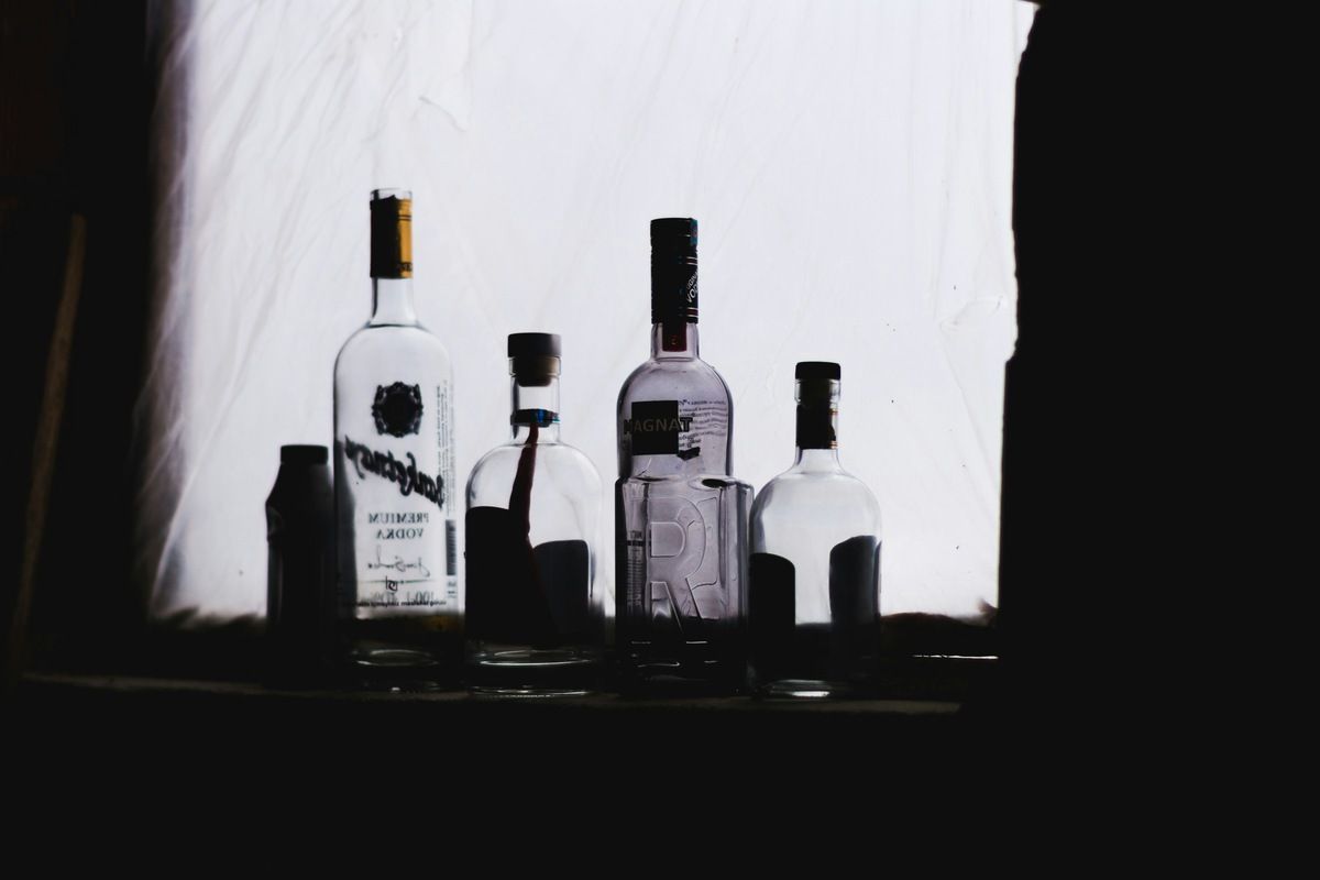 Bottles of alcohol sitting on a shelf in a dark room