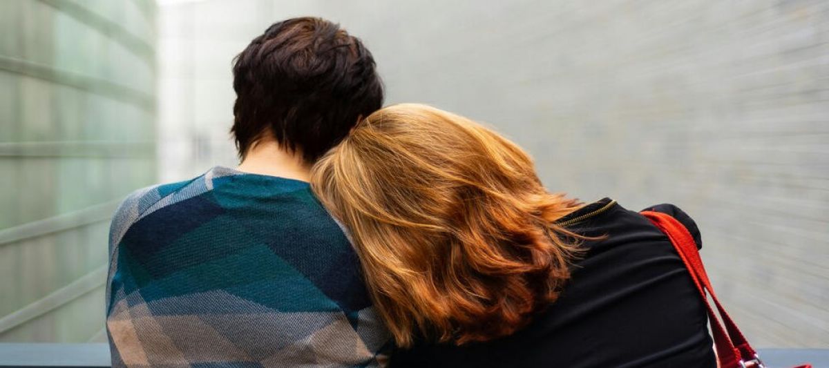 mother and son sit sit by sit with their head tilted towards each other as the son struggles with mental health issues