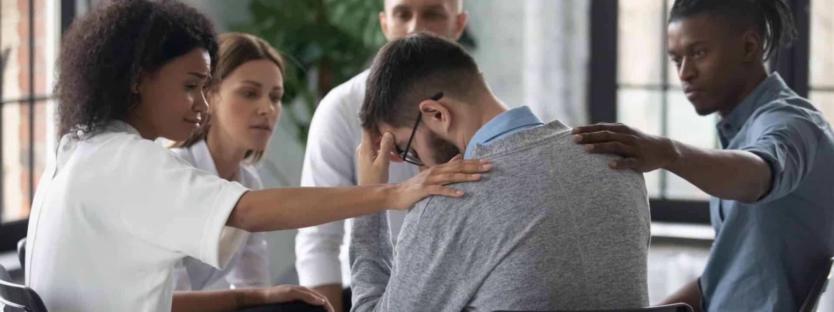 man sits in a group therapy session with his fellow peers