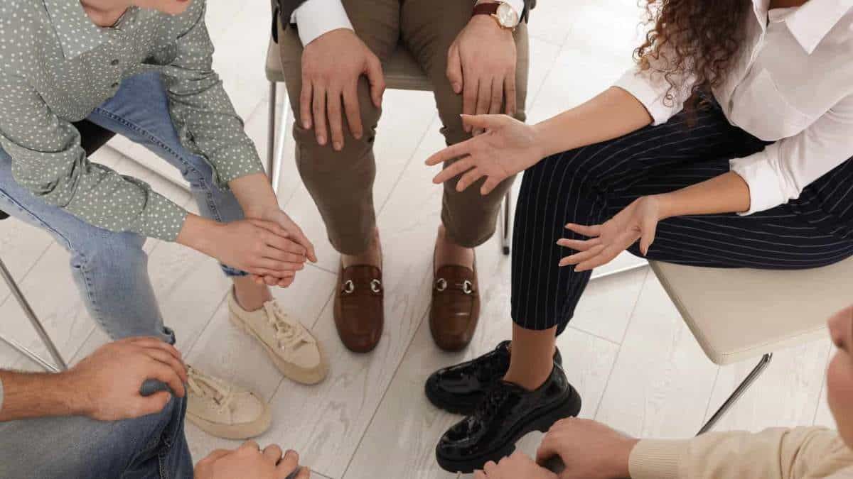 A supportive group therapy session where individuals openly share their thoughts, sparking the consideration: Do I need rehab?