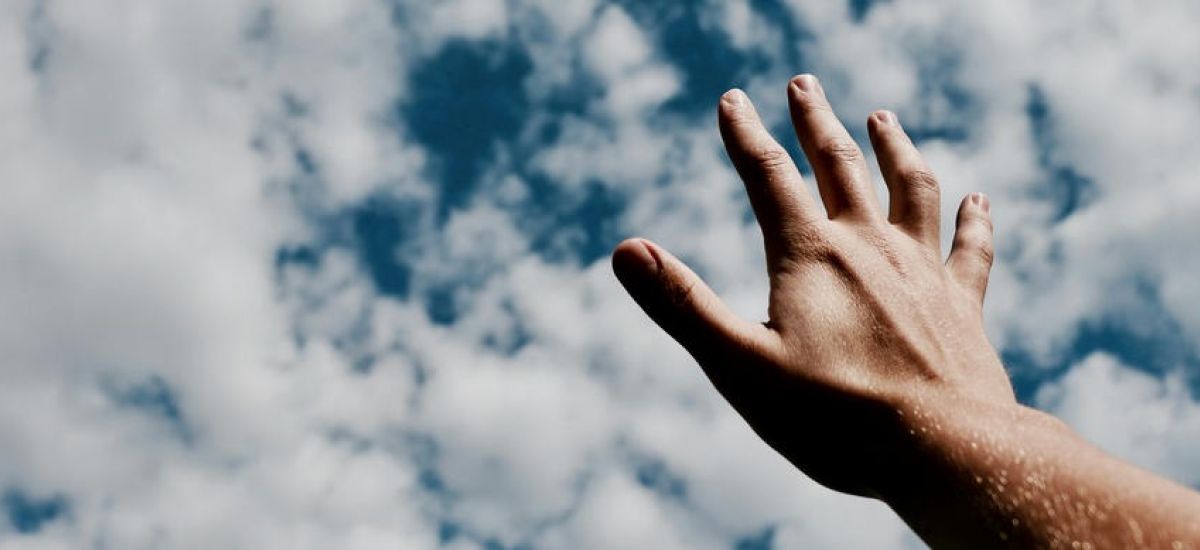 a women is reaching her hands to the sky
