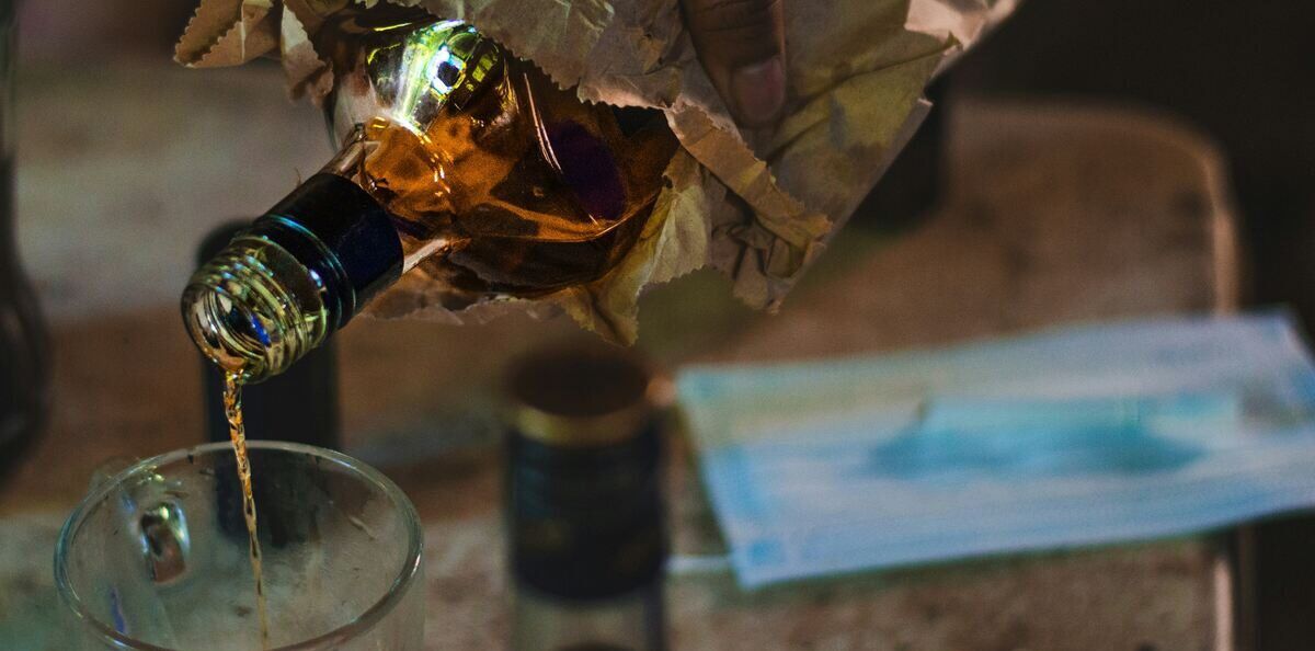 Hard alcohol being poured into a glasses