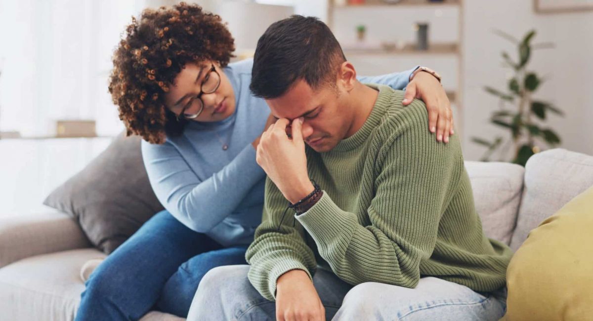 man with a substance abuse issue comforted by a loved one