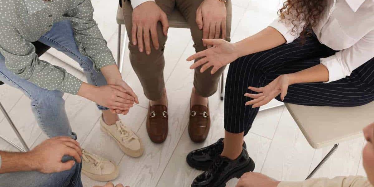 A supportive group therapy session where individuals openly share their thoughts, sparking the consideration: Do I need rehab?