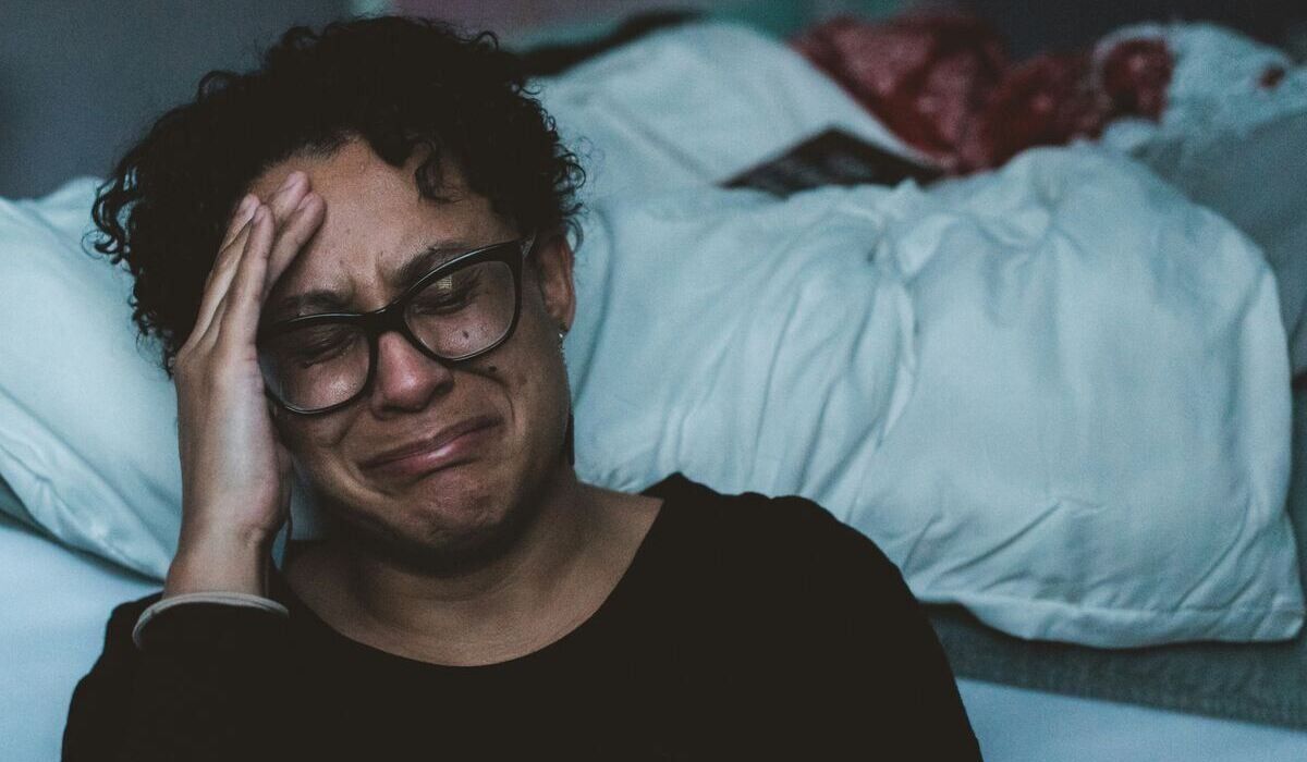 person sitting up late at night crying because they are dealing with mental health stuggles