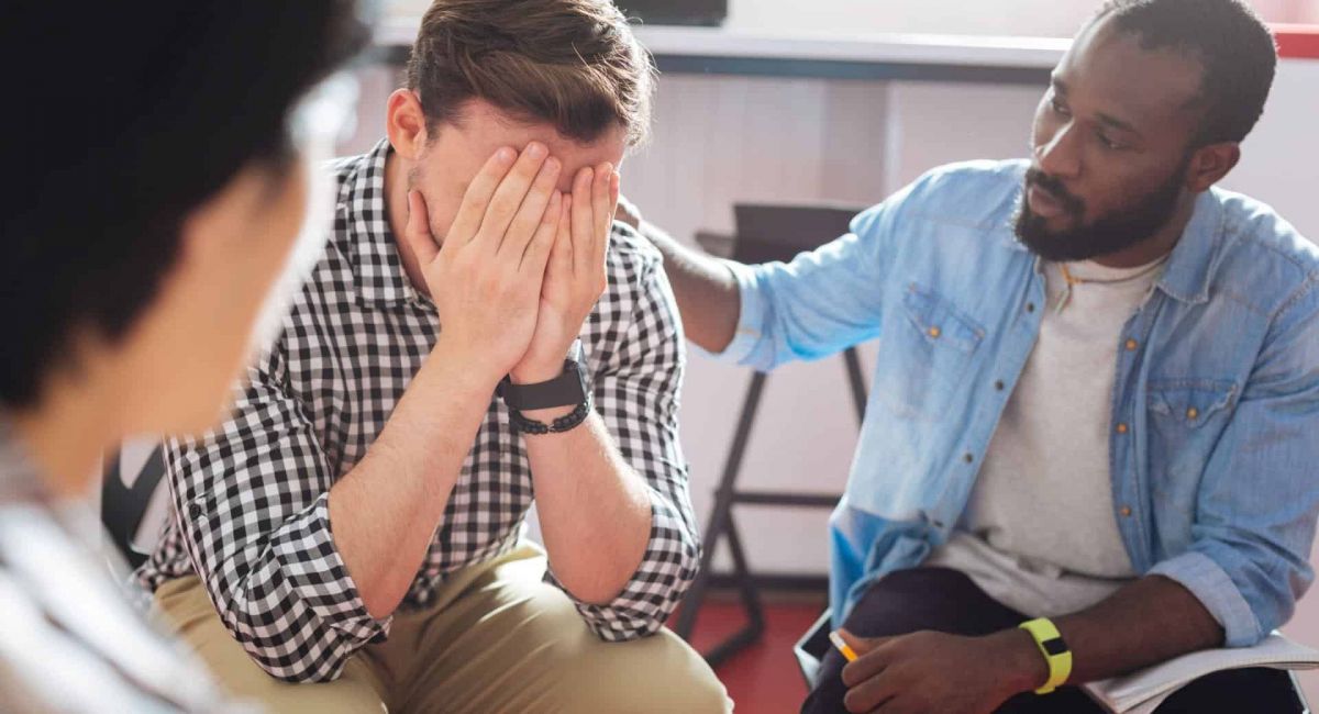 group of men in a group therapy session to deal with the struggles of addiction