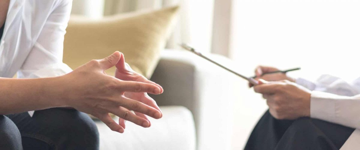 person beginning stages of addiction recovery by talking to an intake counselor at a rehab center