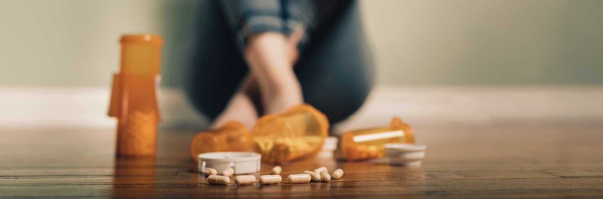 Spilled prescription pills on the floor near a person’s feet, symbolizing substance abuse and the need for addiction therapy and treatment in Tennessee at Freeman Recovery Center.