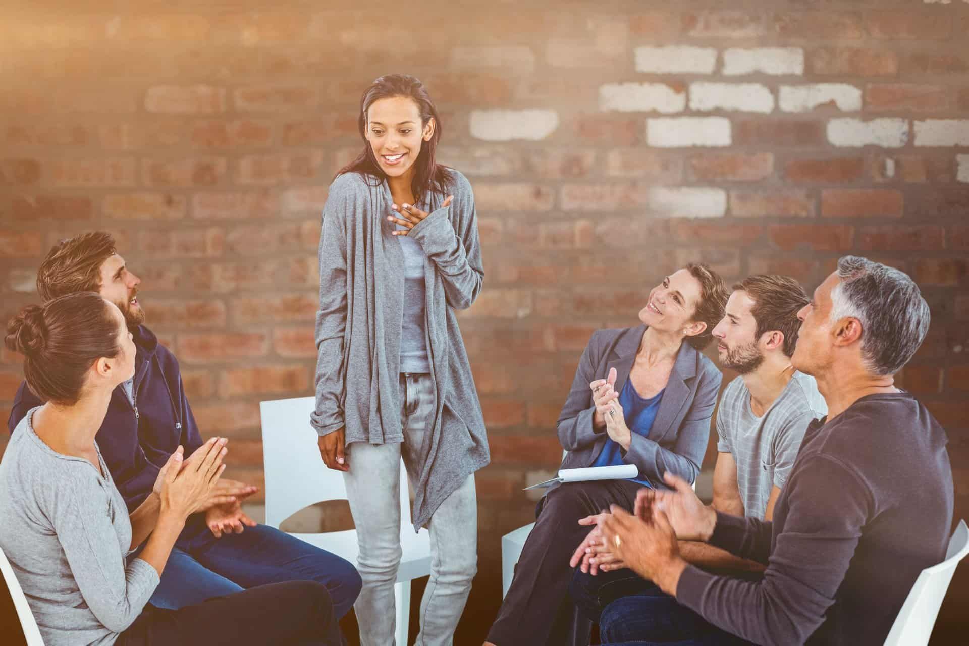 woman speaks up during peer support group at rehab center