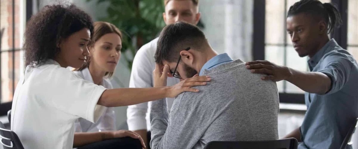 A man wearing glasses holds his head and screams in frustration, symbolizing emotional distress and the need for mental health or addiction support.