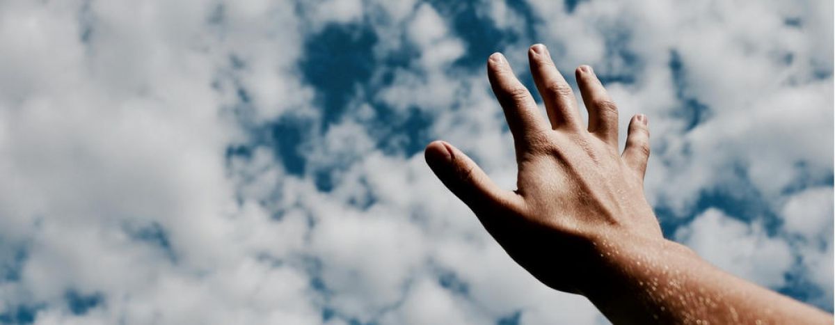 a women is reaching her hands to the sky