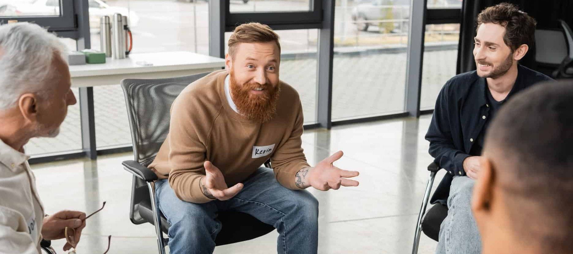 a man sits in a support group therapy excited about his recovery