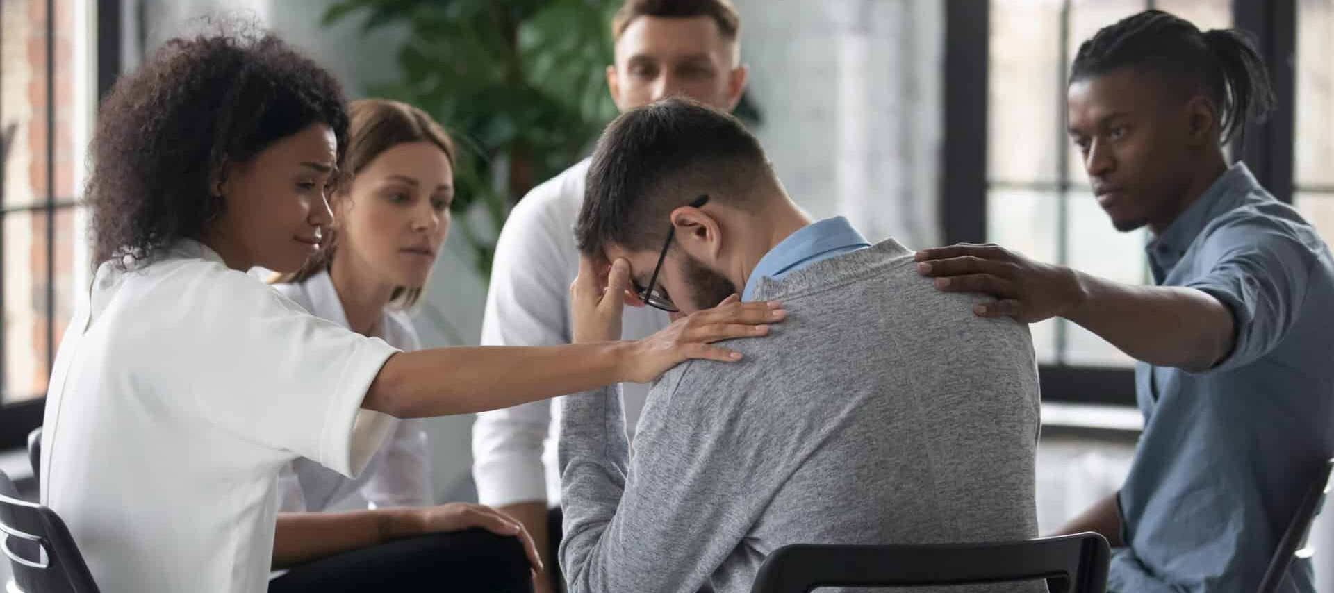 man sits in a group therapy session with his fellow peers