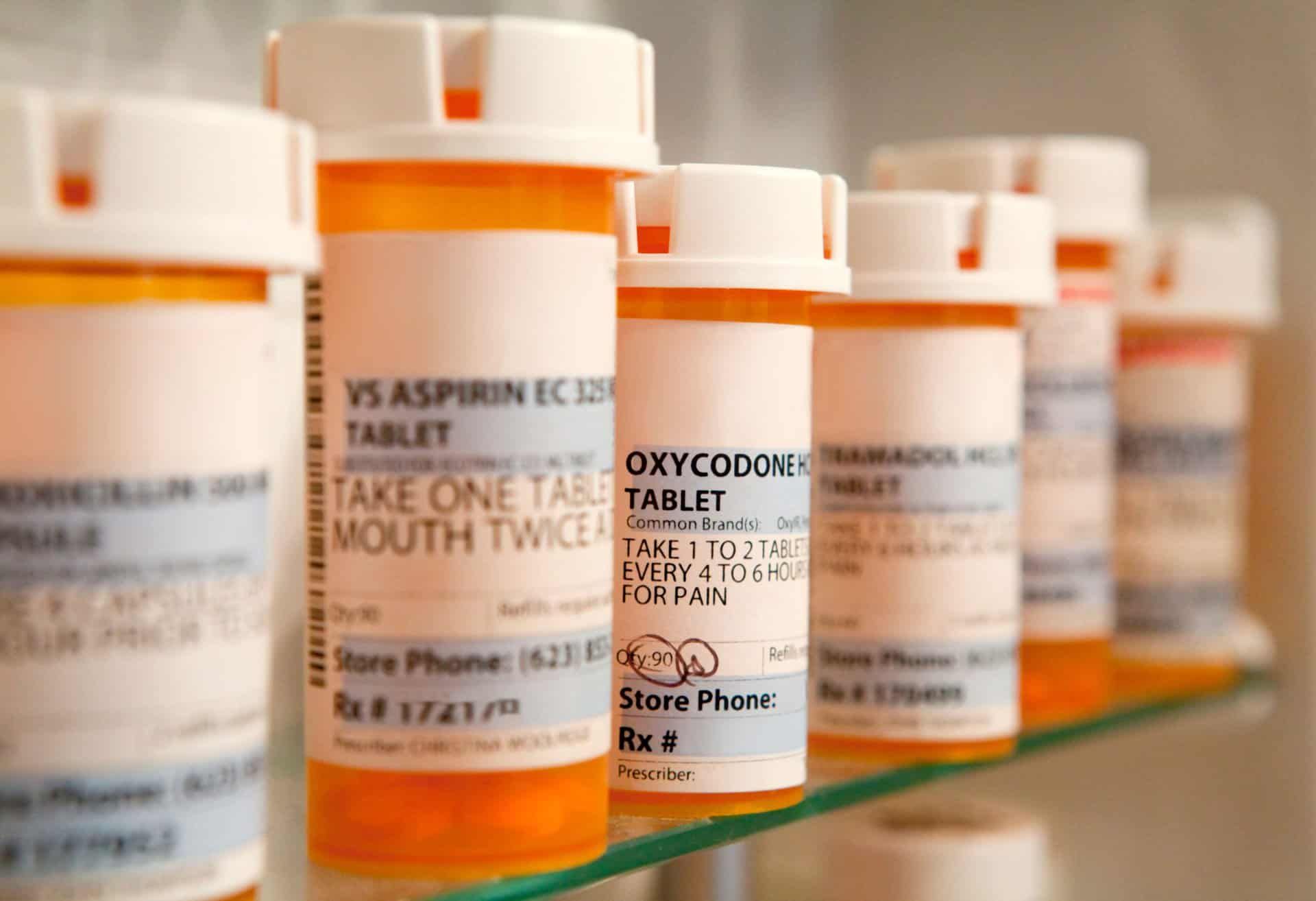 Pill bottles sit on a shelve in a bathroom representing oxycodone addiction